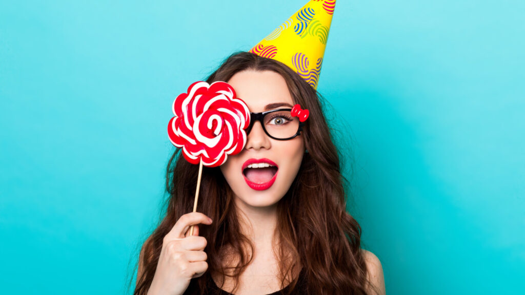 happy smiling woman with a sucker party hat glasses