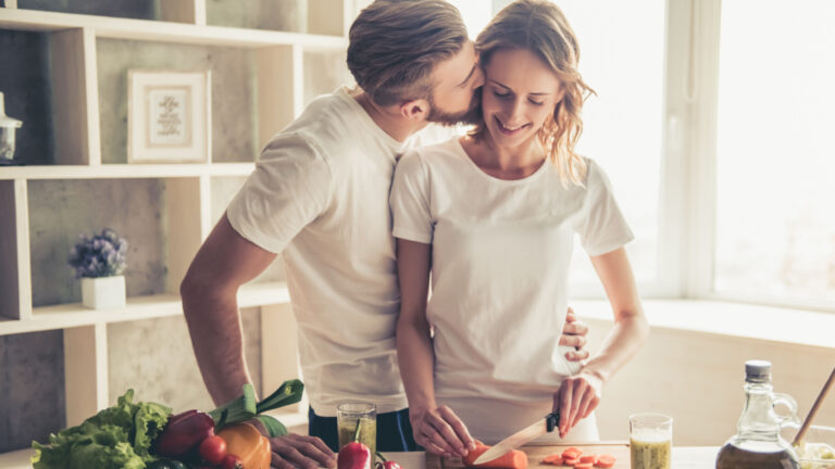 happy couple in the kitchen man woman kiss healthy cooking kitchen vegetables