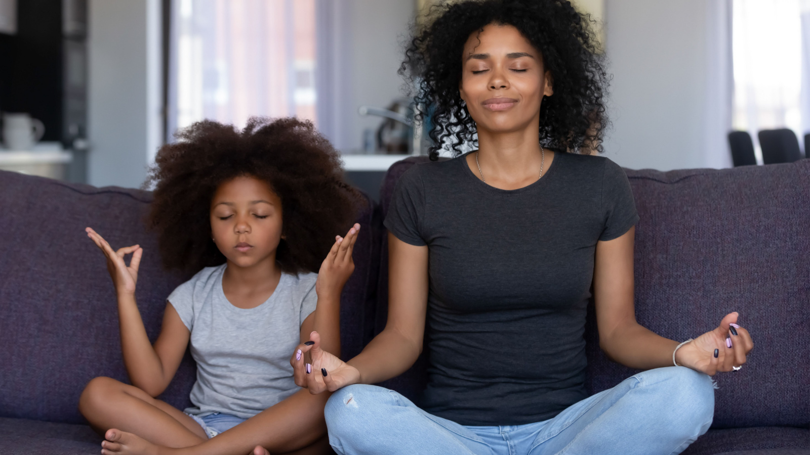 mom and daughter meditating on the couch happy zen