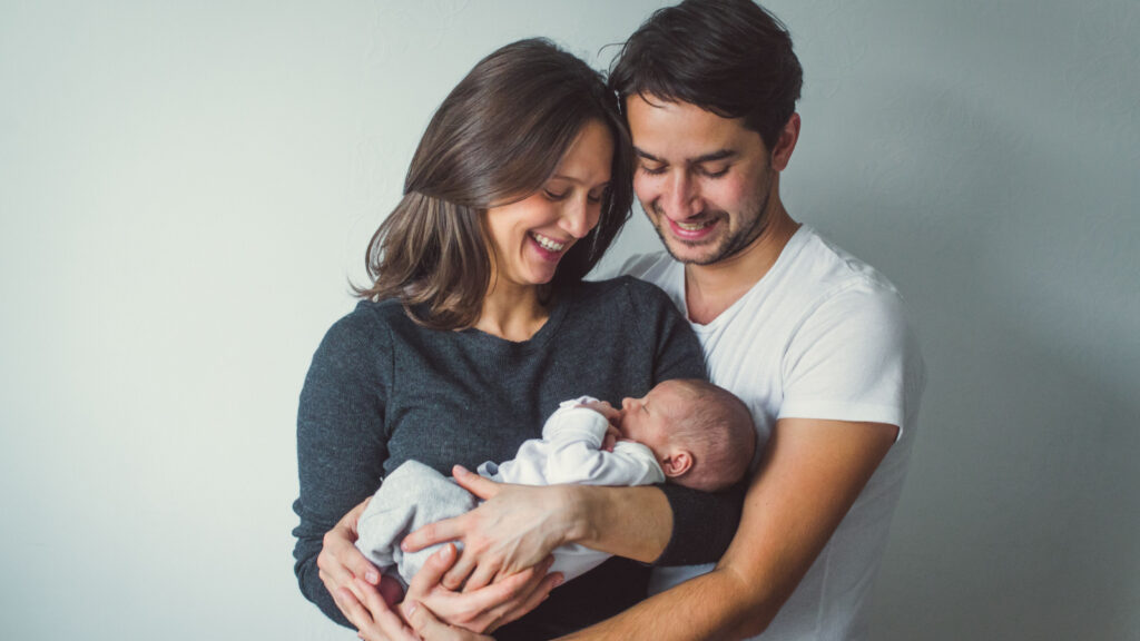 family of three with newborn baby mom dad happy content love
