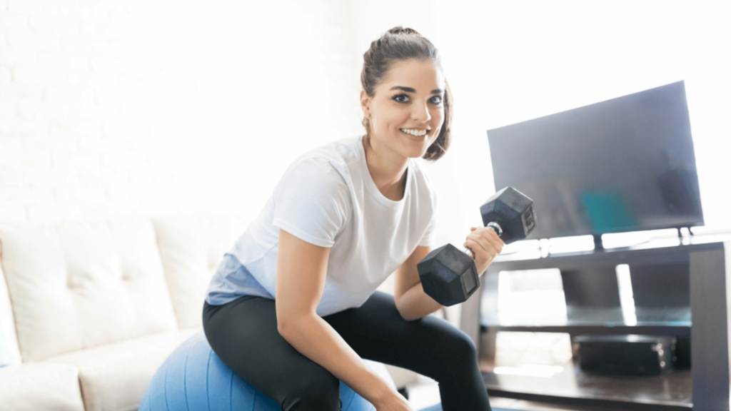 woman sitting on an exercise ball arm weights happy exercise